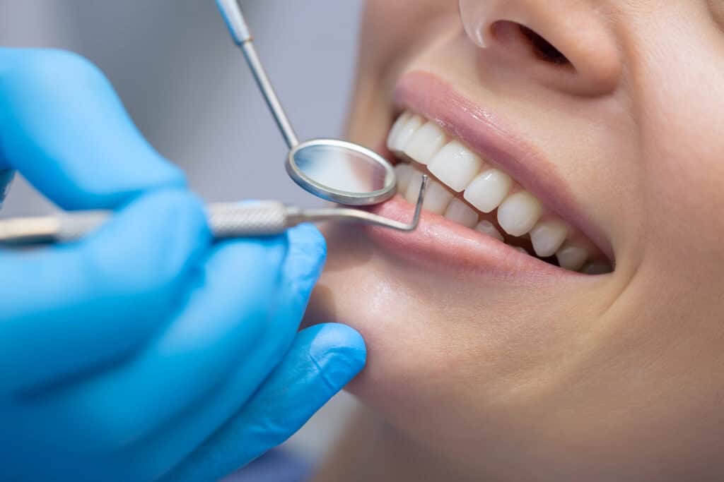 Dental professional performing a routine examination and professional teeth cleaning.
